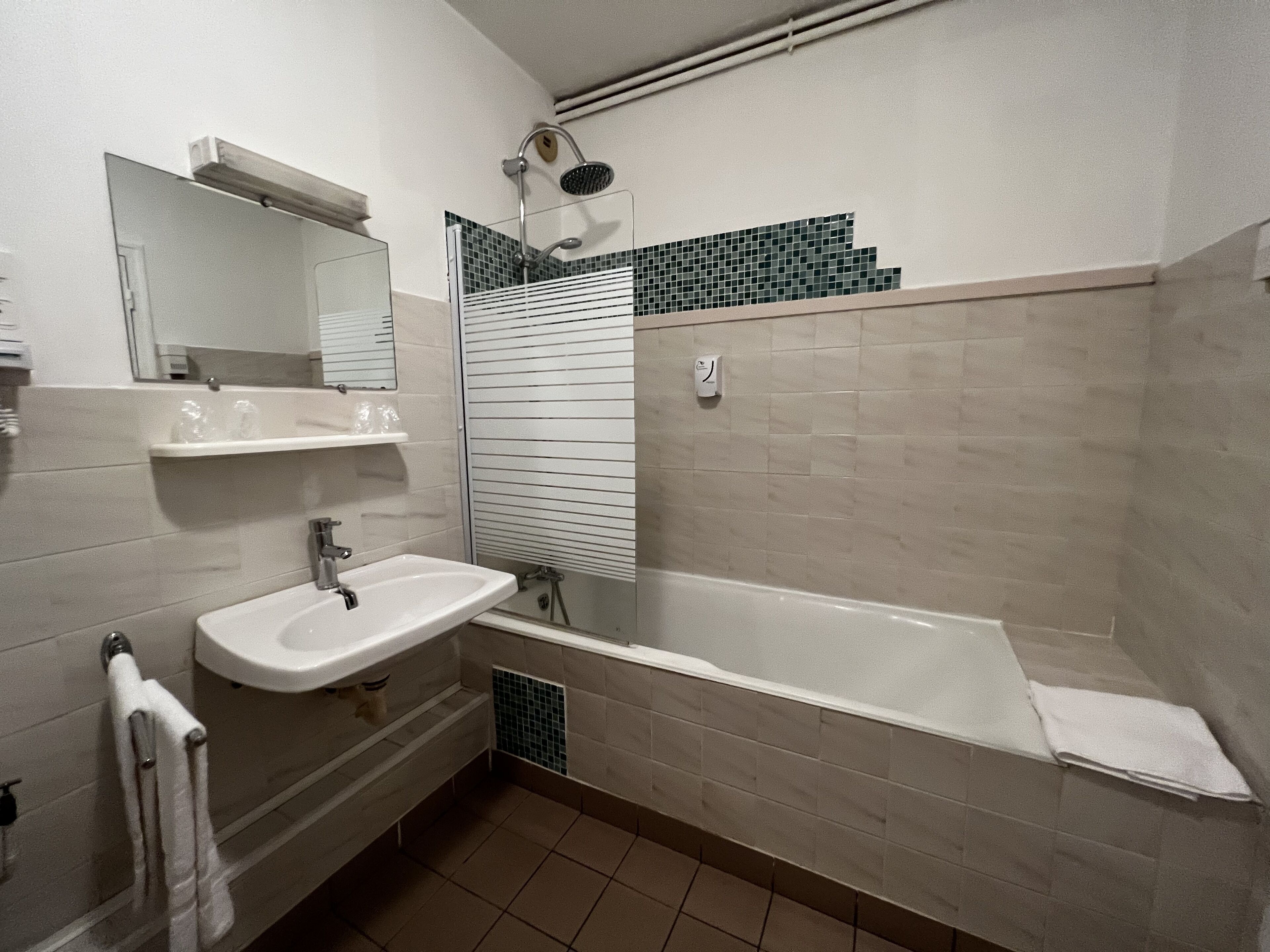 Une salle de bain avec un lavabo, un miroir et une baignoire.