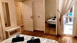 A bedroom with a bed, a bench, and a wardrobe.