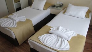 A hotel room with two single beds, each with a white pillow and a towel. - Kadikoy Sahra Otel (Istanbul)
