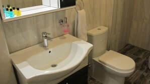 A bathroom with a white sink, a toilet, and a mirror above the sink. - Kadikoy Sahra Otel (Istanbul)