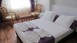 A hotel room with a bed, two chairs, a small table, and a window with curtains. - Kadikoy Sahra Otel (Istanbul)