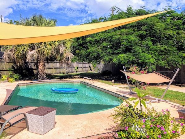 A backyard with a swimming pool, a hammock, and a wooden fence. - 3 Bedroom 2 Bath House with pool - Close to the beach and downtown (Stuart)