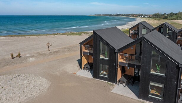 A coastal property with modern cabins featuring balconies, large windows, and a view of the beach and sea. - Stunning apartment in Slagelse (Slagelse)