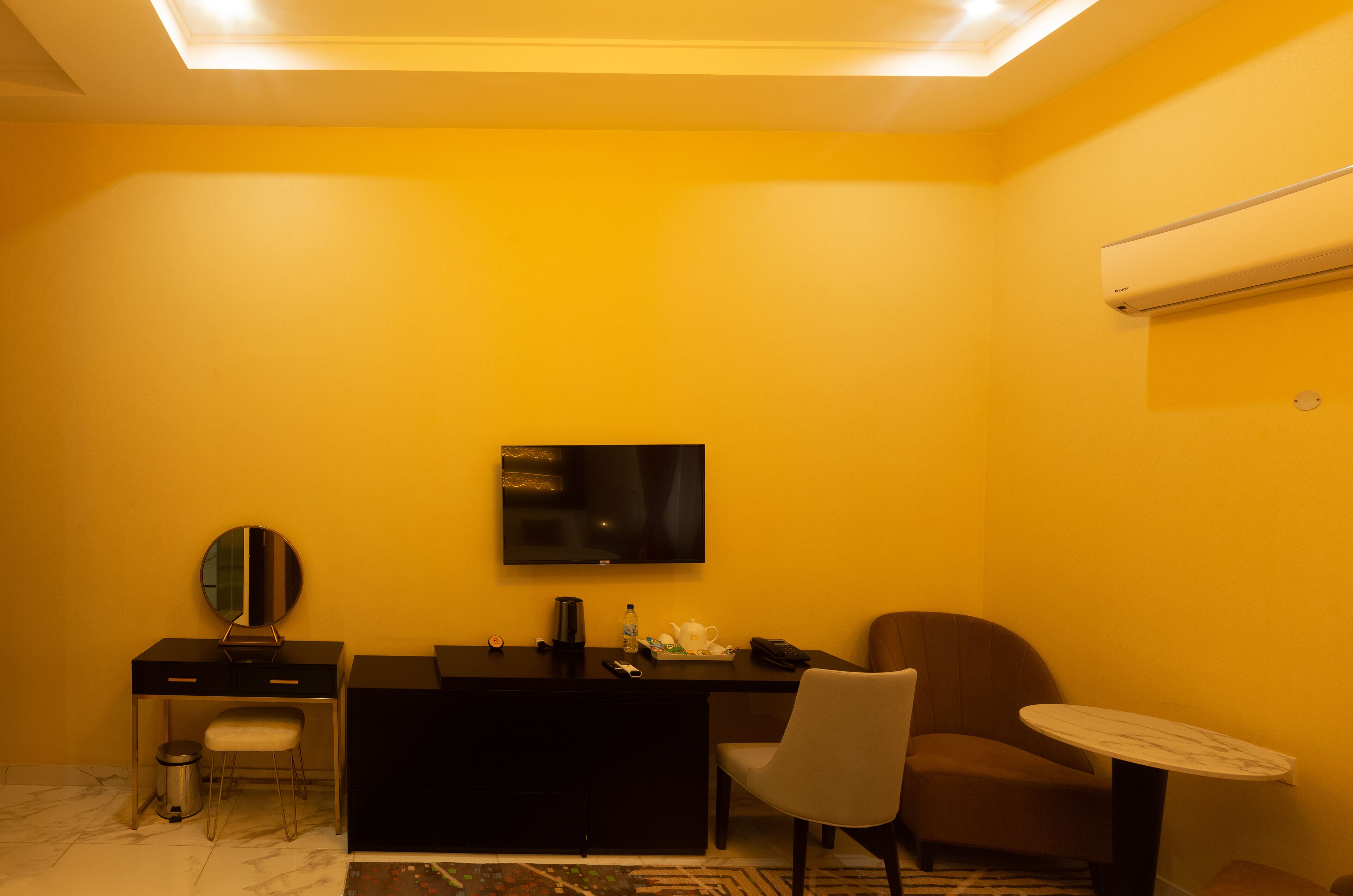Una habitación de hotel pequeña con escritorio, silla y una mesita redonda.