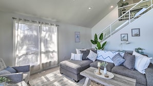 Una sala de estar moderna con un sofá modular, una mesa de centro y una escalera.