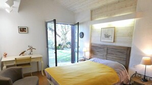 A bedroom with a bed, a desk, a chair, and a window with a view of the outdoors. - Villa ' L'échappée Belle' (SEIGNOSSE)