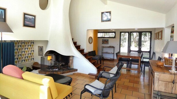 A spacious living area with a fireplace, a yellow sofa, and a dining table with chairs. - Villa ' L'échappée Belle' (SEIGNOSSE)