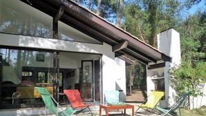 A modern house with a patio area featuring outdoor furniture and a garden. - Villa ' L'échappée Belle' (SEIGNOSSE)