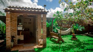 A small brick building with a tiled roof, a hammock, and a sign reading "Rece Pão". - Pousada Recanto Caiçara (São Miguel dos Milagres)