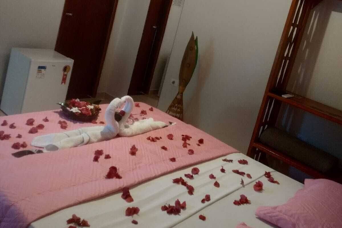 Una habitación de hotel con cama, televisión, aire acondicionado y minibar.