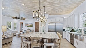 A spacious kitchen with a large island, white cabinetry, and stainless steel appliances.