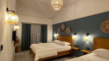 Suite familiar, 2 habitaciones, vistas parciales al mar | Ropa de cama de alta calidad, minibar, caja fuerte y cortinas opacas