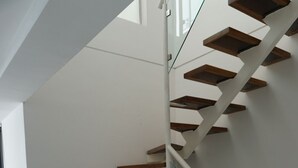Eine moderne Treppe mit Holzboden und Glasgeländern.