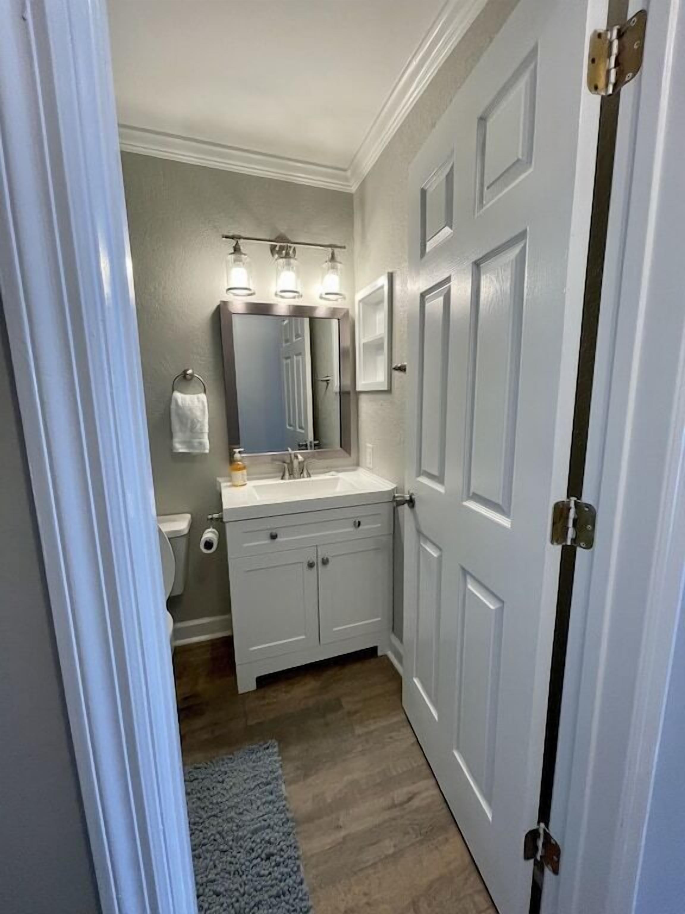 Une petite salle de bain avec un meuble-lavabo blanc, un miroir et des toilettes.