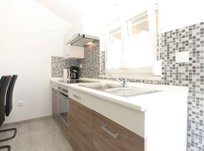 Réfrigérateur, un four, surface de cuisson, vaisselle et ustensiles