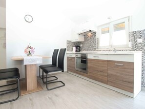 Réfrigérateur, un four, surface de cuisson, vaisselle et ustensiles