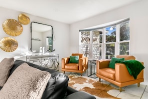 Relax in this stylish living room with a leather sofa, armchairs, and a glass coffee table.