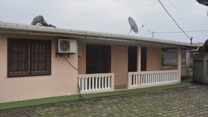 A single-story building with a satellite dish, air conditioning unit, and a green awning. - FURNISHED HOUSE COSY (Libreville)