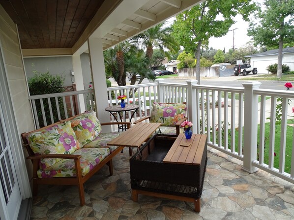 Relax in this serene outdoor seating area with a sofa, bench, and table.
