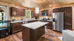 A modern kitchen with wooden cabinets, stainless steel appliances, and a large island.