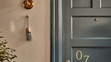 Una puerta con el número 07, una lámpara de pared y un timbre.