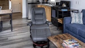 Un espacio habitable compacto con cocina, comedor y zona de estar con sofá y mesa de centro.