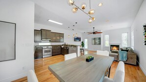 A spacious kitchen with modern appliances and a dining area with a wooden table and white chairs.