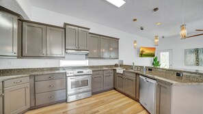 Una cocina moderna con electrodomésticos de acero inoxidable, encimeras de granito y una isla grande.