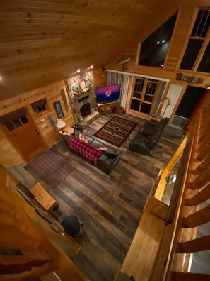 A cozy cabin interior with a fireplace, wooden floors, a sofa, and a television. - Close to trails, COZY Cabin, close to the water, fireplace, Fall colors (Hayward)