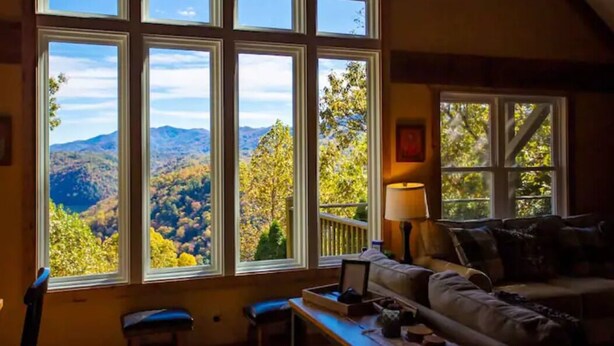 A cozy room with a large window offering a mountain view.