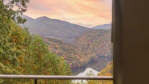A balcony with a view of a valley and mountains.