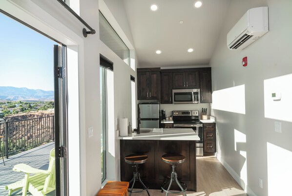 Enjoy a functional workspace with a large island, sink, and bar stools, offering a stunning view of the surrounding landscape.