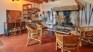 A rustic interior with wooden beams, a fireplace, and traditional furniture.