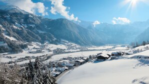 A snow-covered mountain village with traditional houses and a clear sky.