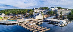 Un hôtel situé sur la côte, composé de plusieurs bâtiments, avec un port de plaisance où sont amarrés des bateaux, et une piscine.