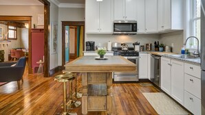 A modern kitchen with white cabinets, stainless steel appliances, and a wooden island. - ✨️Family Friendly Getaway✨️Small or Large Groups Welcome - Eclectic Design Gem! (Johnson City)