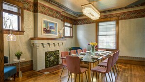 A dining area with a wooden table, pink chairs, and a chandelier. - ✨️Family Friendly Getaway✨️Small or Large Groups Welcome - Eclectic Design Gem! (Johnson City)