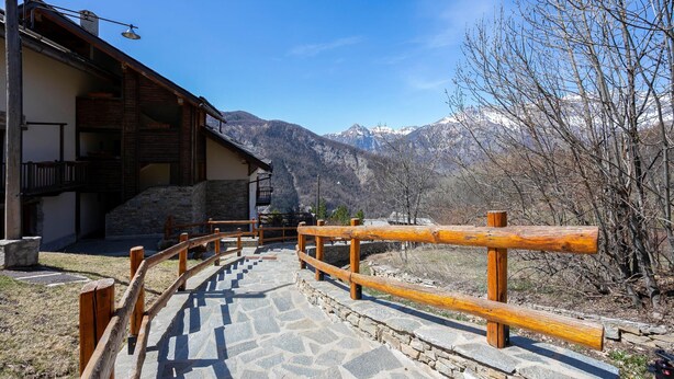 A stone pathway leading to a building with a wooden fence, surrounded by mountains. - Rebecca's House among the greenery, Bardonecchia, Italy (Bardonecchia)