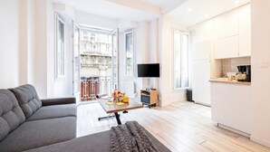 Un salon moderne avec un canapé, une table basse et un téléviseur.