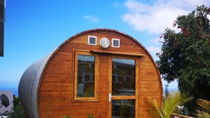 Une cabane en bois avec un toit incurvé, deux fenêtres et une porte.
