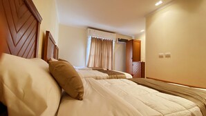 A hotel room with two beds, a wardrobe, and a window with curtains. - Cairo house - Hostel (Cairo)