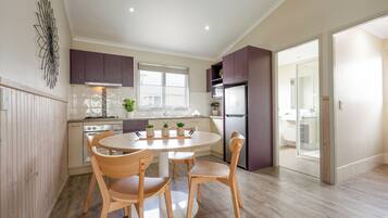 A modern kitchen with wooden cabinets, a round dining table, and chairs.