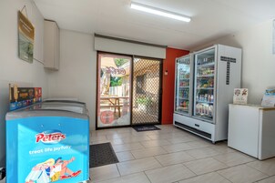 Habitación con un refrigerador grande, una máquina expendedora y una puerta que da al exterior.