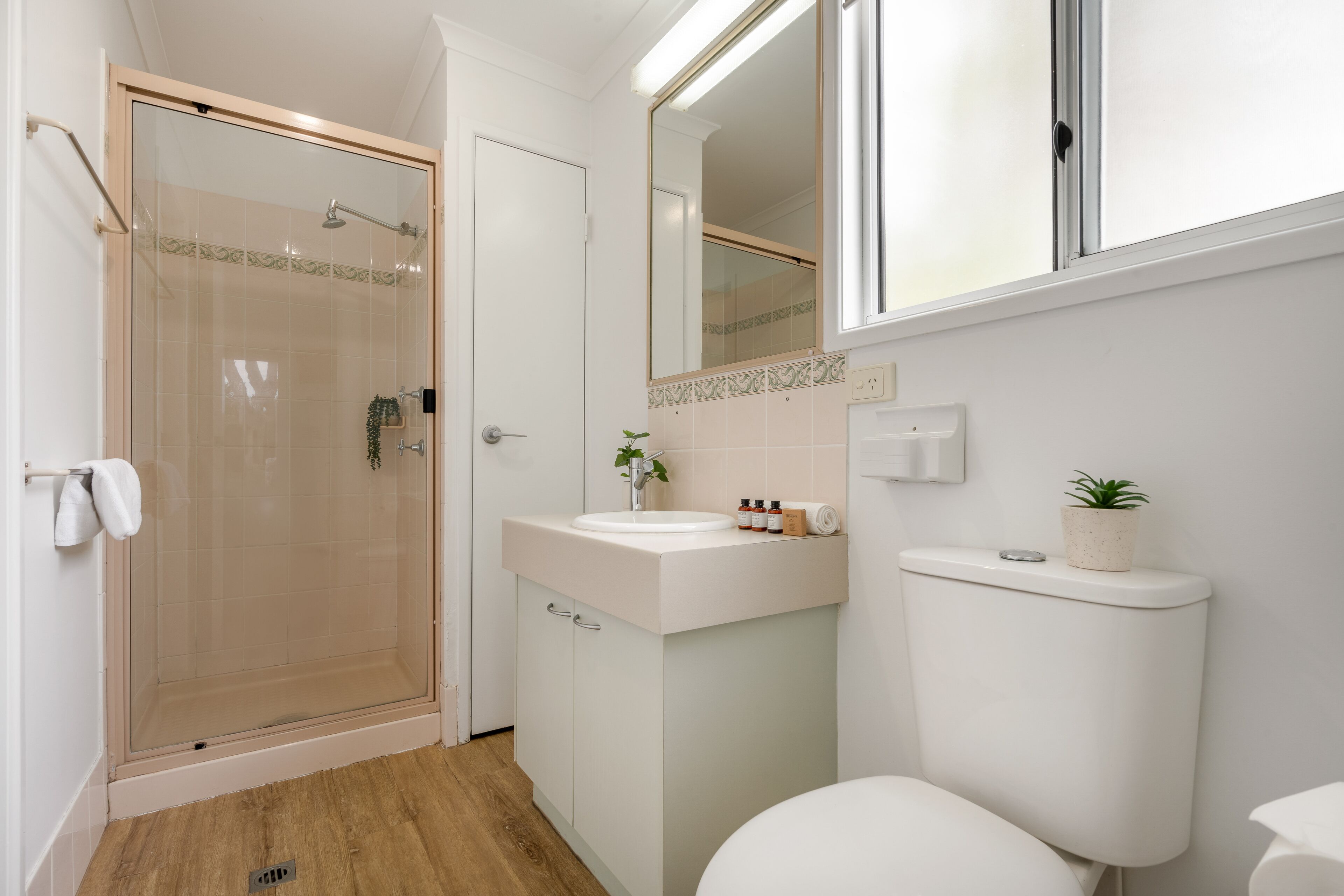 Ein Badezimmer mit Duschkabine, Waschbecken in Weiß und Toilette.