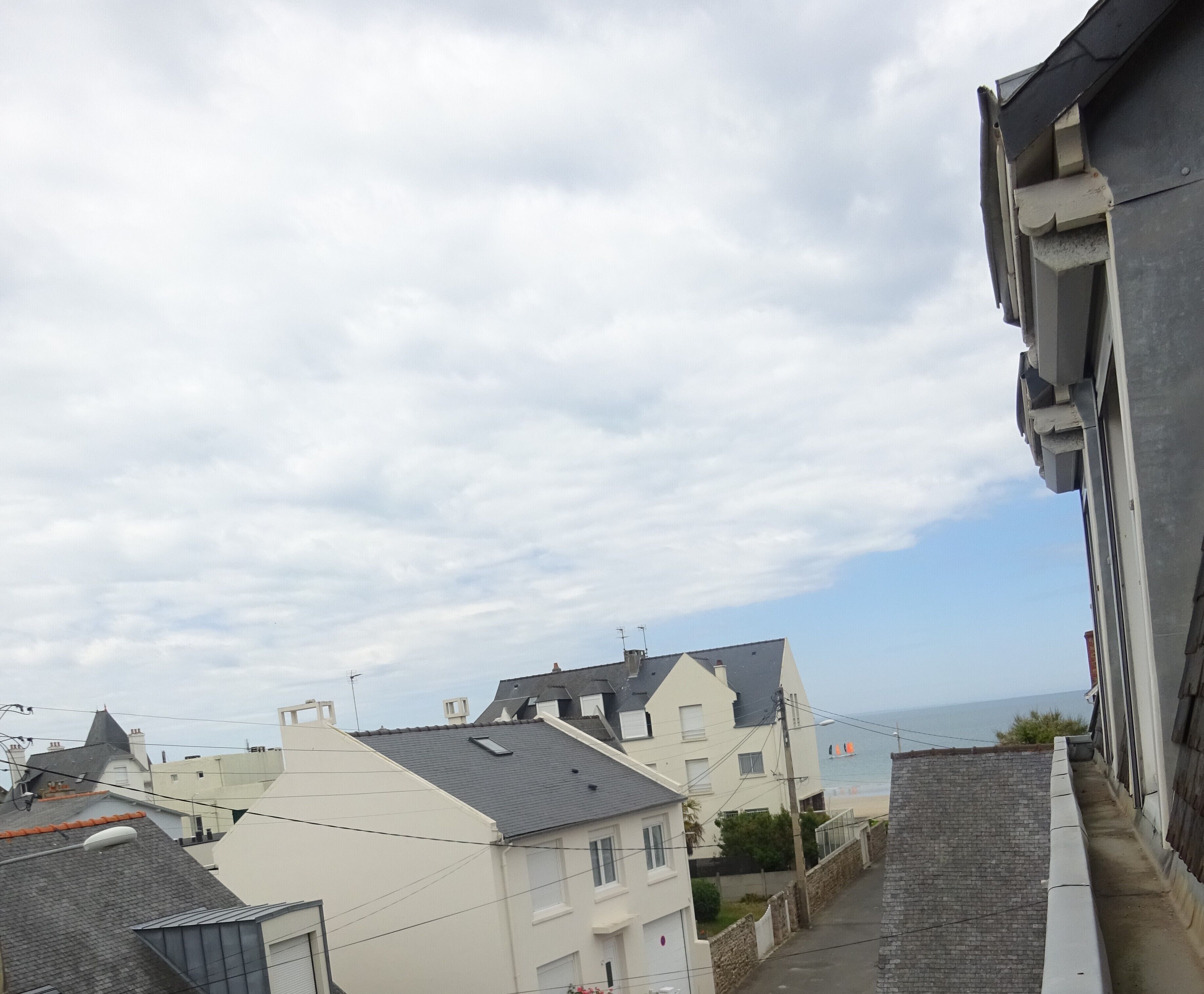 Un quartiere residenziale con edifici, una strada stretta e vista sul mare.