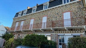 Un bâtiment en pierre de deux étages, doté de nombreuses fenêtres et de balcons.