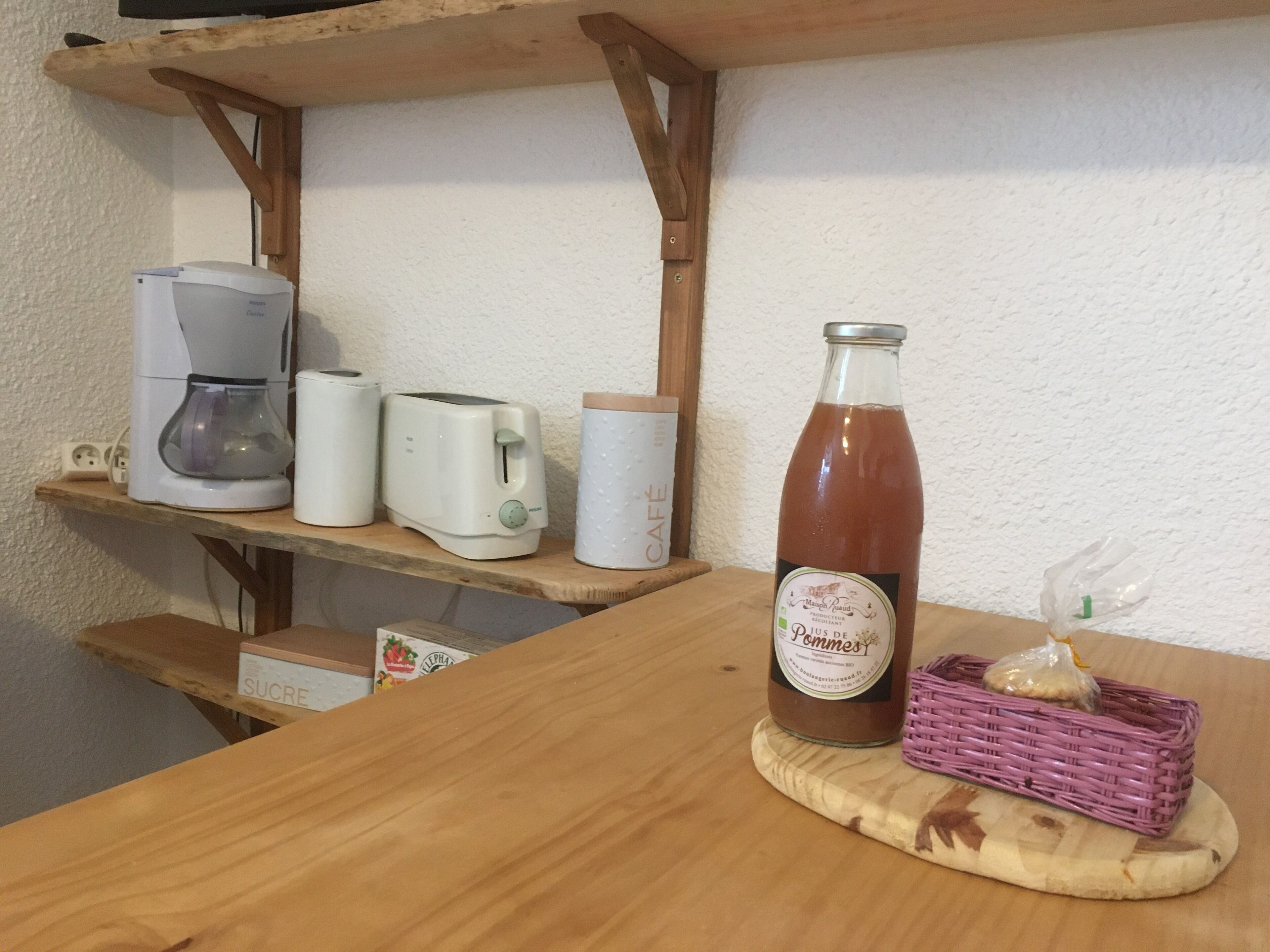 A kitchen counter with a coffee maker, toaster, and a bottle of juice.