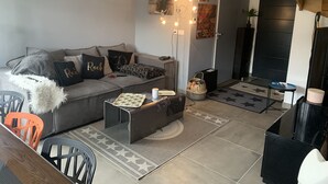Una sala moderna con un sofá gris, una mesa de centro y un tapete estampado.