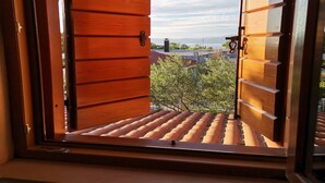 Une porte en bois donnant sur un jardin sur le toit, avec une vue sur la ville en arrière-plan.