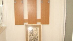 Ein Zimmer mit einem Holzschrank, einem gerahmten Bild und einem Spiegel an der Wand.